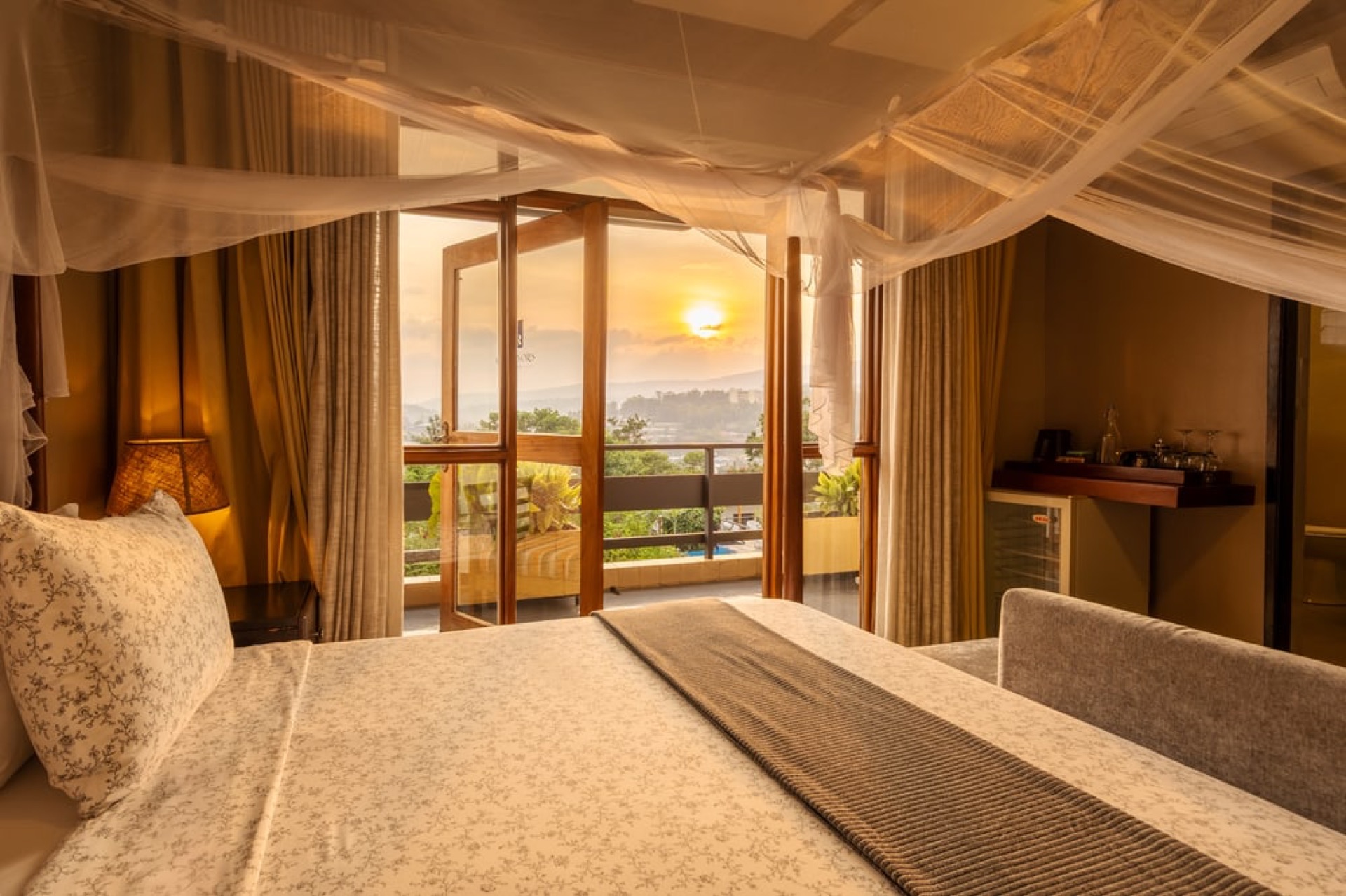 A lodge bedroom looking out over hills at sunset, Rwanda